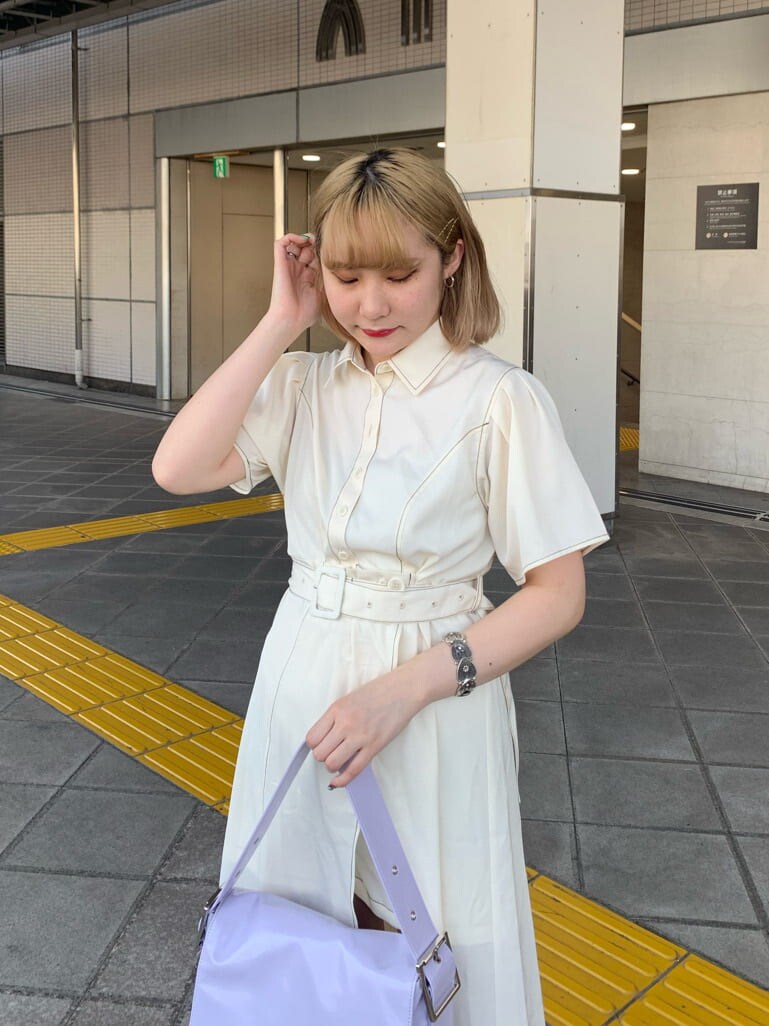 パープル系のハンドバッグ、ホワイト系のワンピース、シルバー系のブレスレットを着用したレディースの夏コーディネートの2枚目の写真