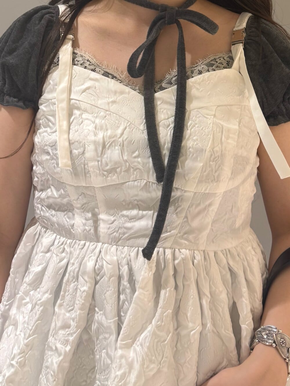 ブラック系のハンドバッグ、ブラック系のブーツ、グレー系のTシャツ/カットソーを着用したレディースの夏コーディネートの7枚目の写真