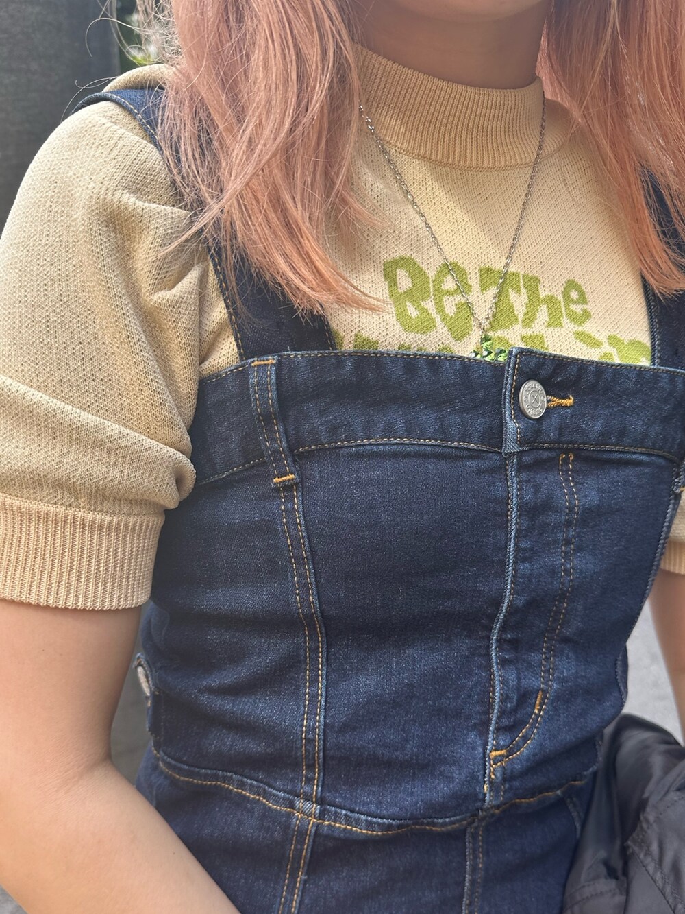 ブルー系のジャンパースカート、ホワイト系のニット/セーター、ブラック系のMA-1を着用したレディースの夏コーディネートの5枚目の写真