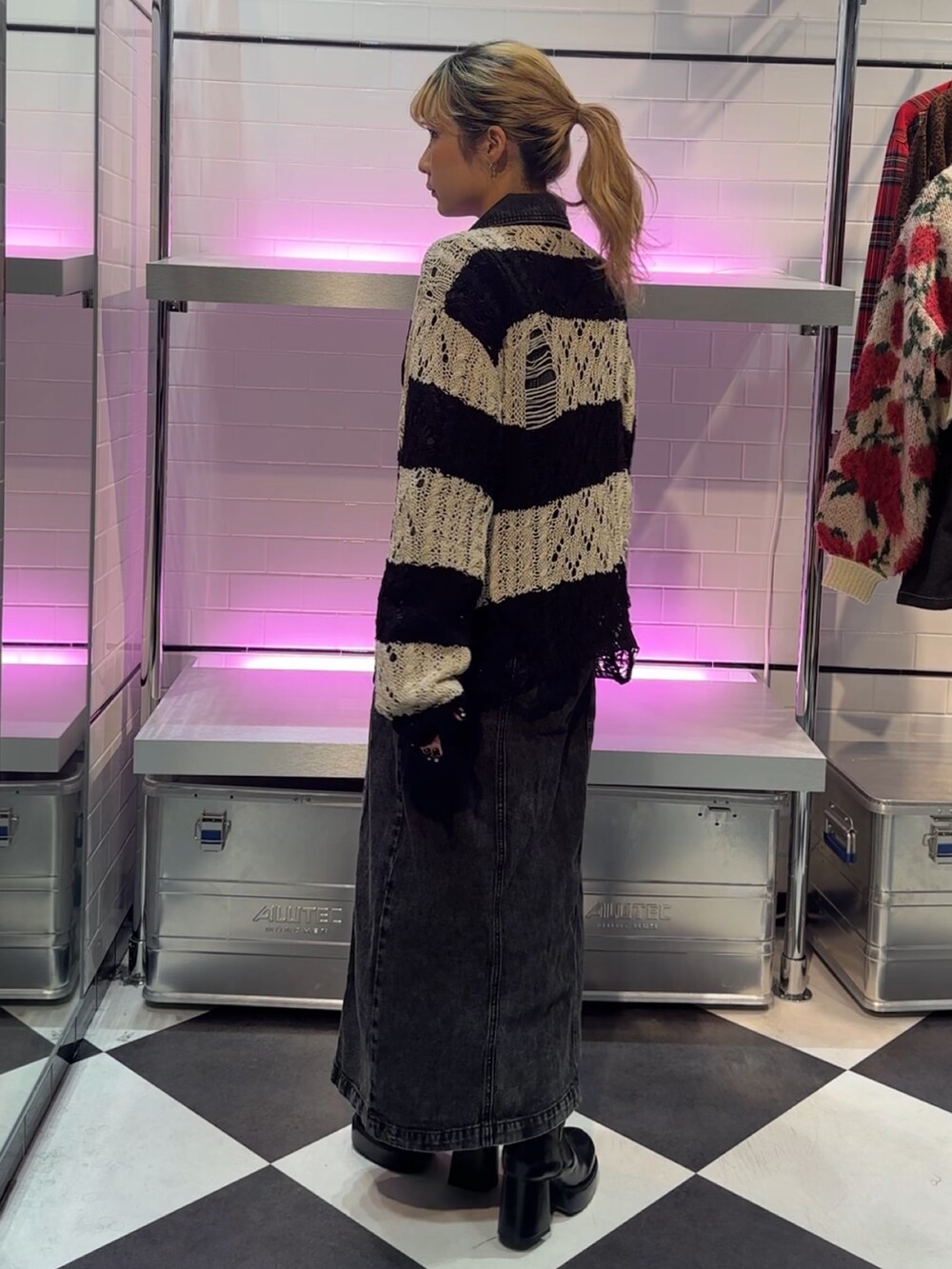 ブラック系のニット/セーター、ブラック系のワンピース、ブラック系のブーツを着用したレディースの冬コーディネートの4枚目の写真