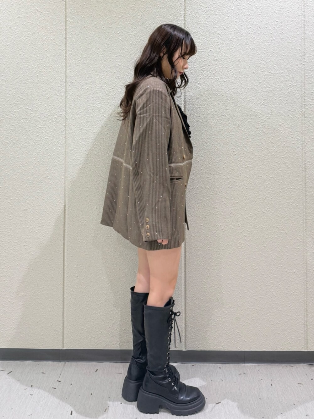 ブラック系のブーツ、ブラウン系のテーラードジャケット、ブラウン系のその他パンツを着用したレディースの秋コーディネートの3枚目の写真