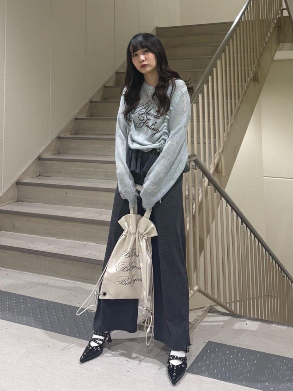 ブルー系のニット/セーター、グレー系のスウェットパンツ、ブラック系のパンプスを着用したレディースの春コーディネートの3枚目の写真