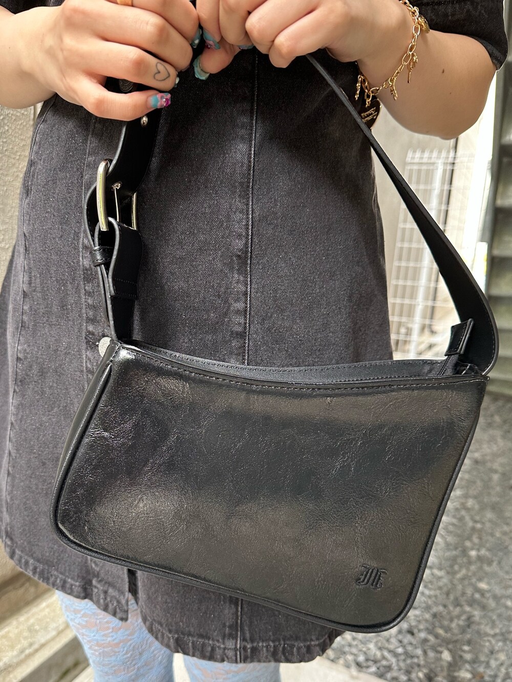 ブラック系のワンピース、ブラック系のハンドバッグ、ゴールド系のピアス（両耳用）を着用したレディースの春コーディネートの8枚目の写真