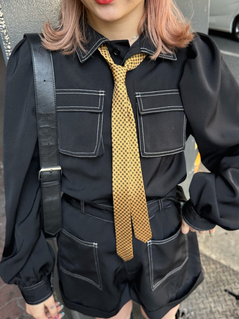 ブラック系のつなぎ/オールインワン、ブラック系のショルダーバッグ、ブラック系のブーツを着用したレディースの春コーディネートの6枚目の写真