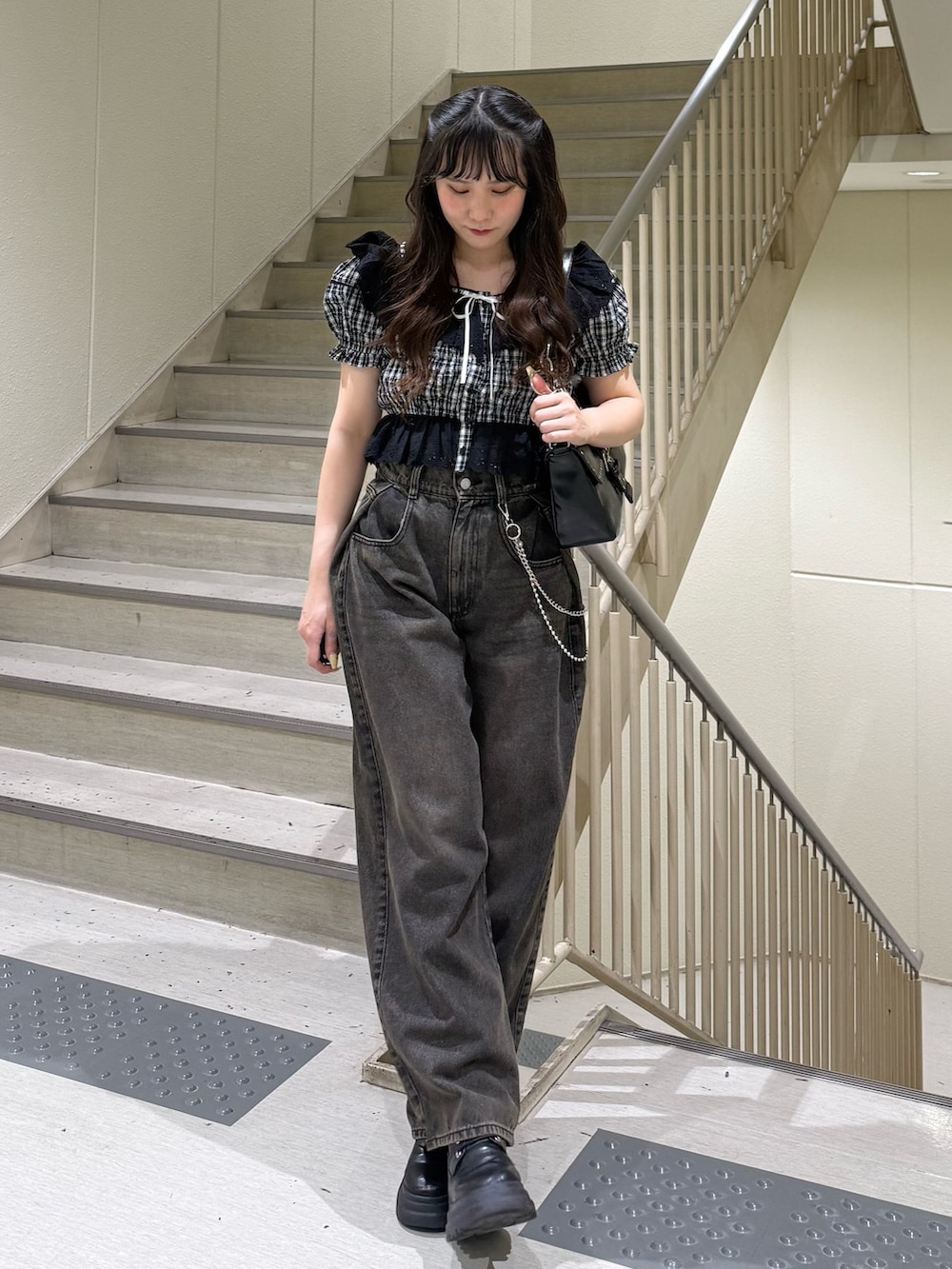 ブラック系のシャツ/ブラウス、ブラック系のデニムパンツ、ブラック系のハンドバッグを着用したレディースの春コーディネートの4枚目の写真