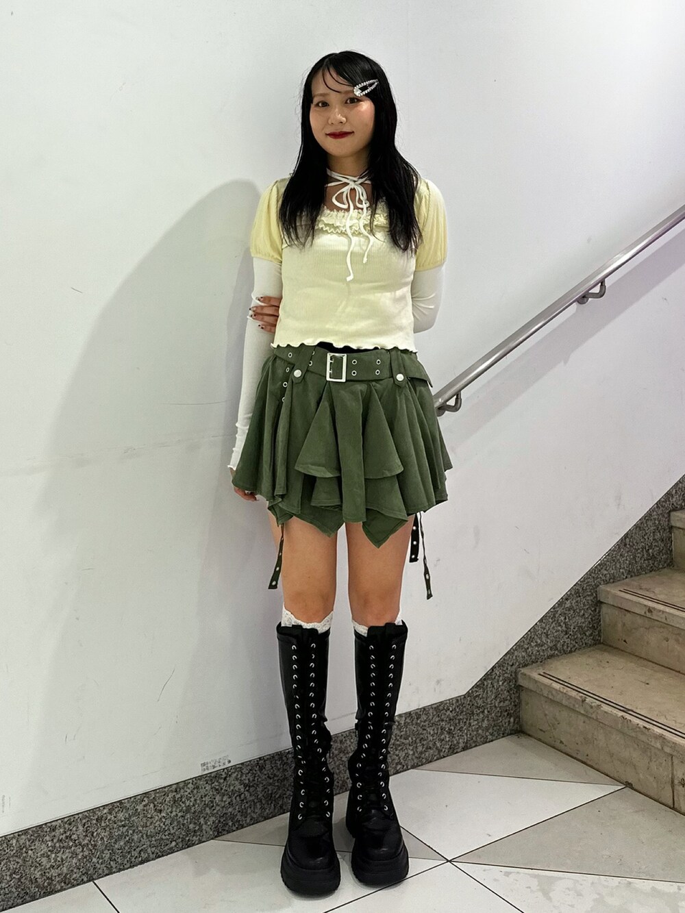 ホワイト系のTシャツ/カットソー、グリーン系のスカート、ブラック系のブーツを着用したレディースの秋コーディネートの5枚目の写真