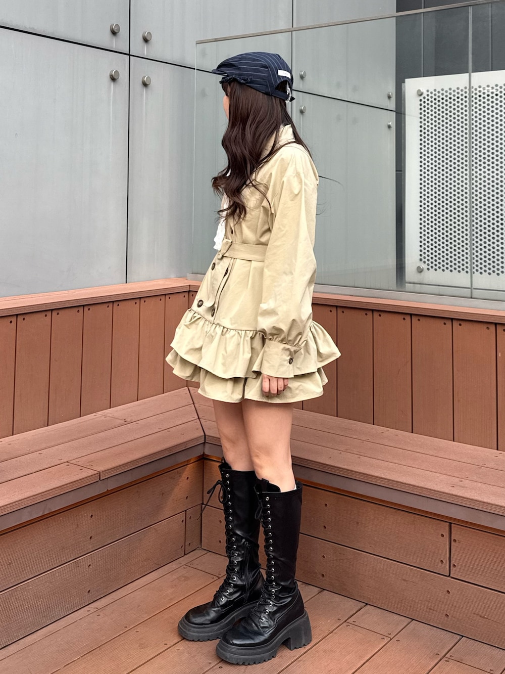 ベージュ系のワンピース、ホワイト系のTシャツ/カットソー、ブラック系のブーツを着用したレディースの冬コーディネートの3枚目の写真