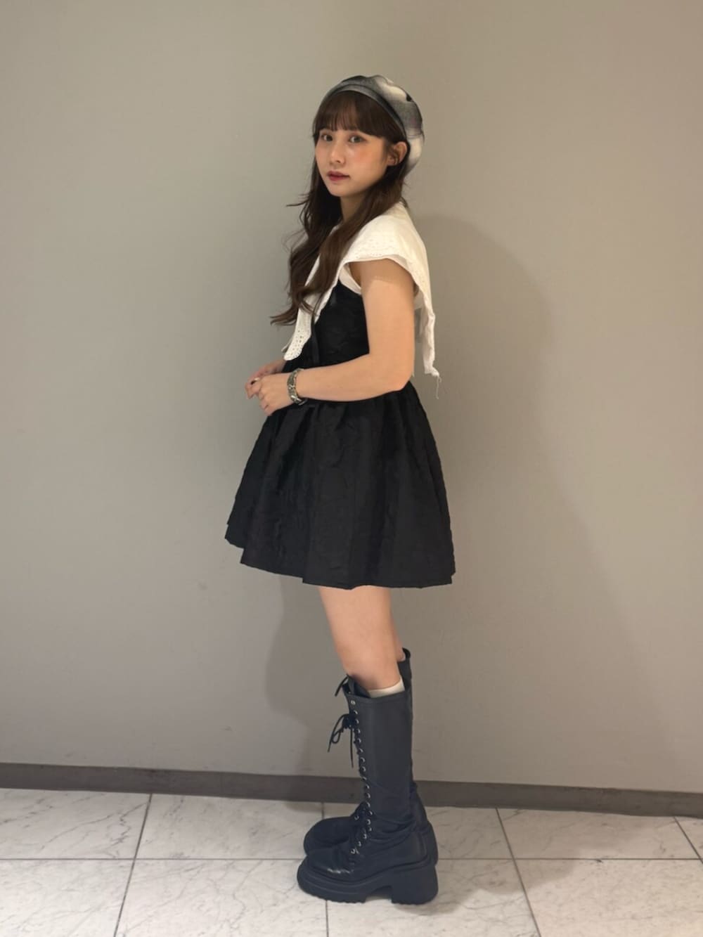 ブラック系のブーツ、ホワイト系のシャツ/ブラウス、ブラック系のワンピースを着用したレディースの夏コーディネートの2枚目の写真