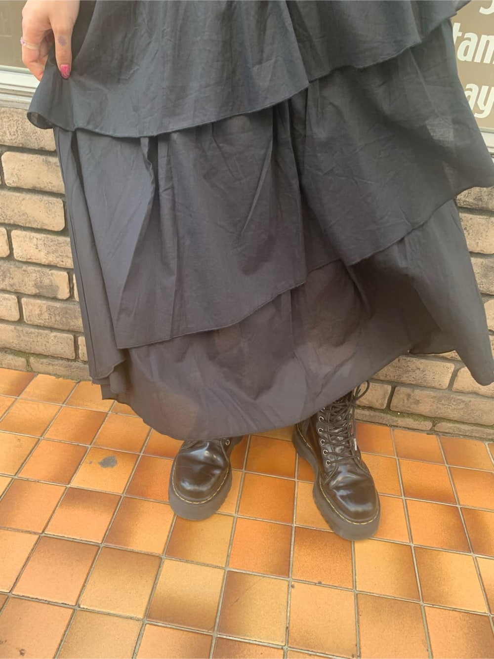 ブラック系のニット/セーター、ブラック系のスカート、シルバー系のブレスレットを着用したレディースの春コーディネートの6枚目の写真