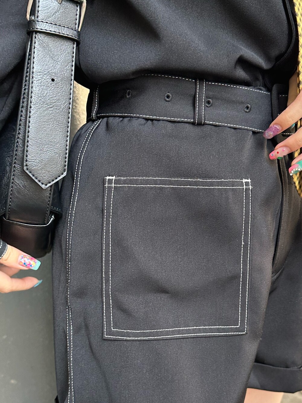 ブラック系のつなぎ/オールインワン、ブラック系のショルダーバッグ、ブラック系のブーツを着用したレディースの春コーディネートの7枚目の写真