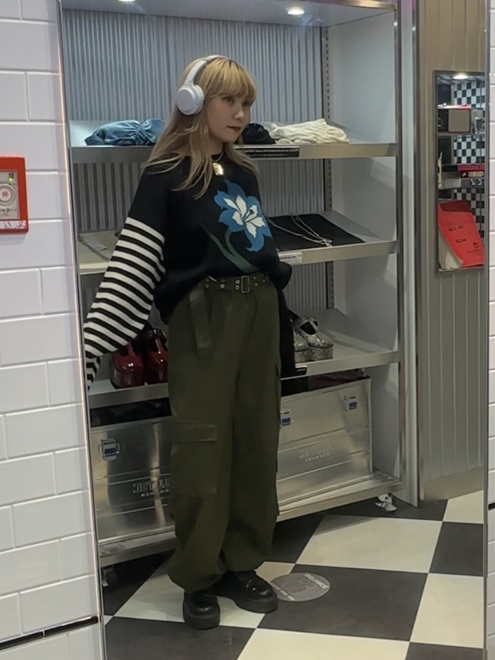 グリーン系のカーゴパンツ、ブラック系のニット/セーター、シルバー系のネックレスを着用したレディースの秋コーディネートの2枚目の写真