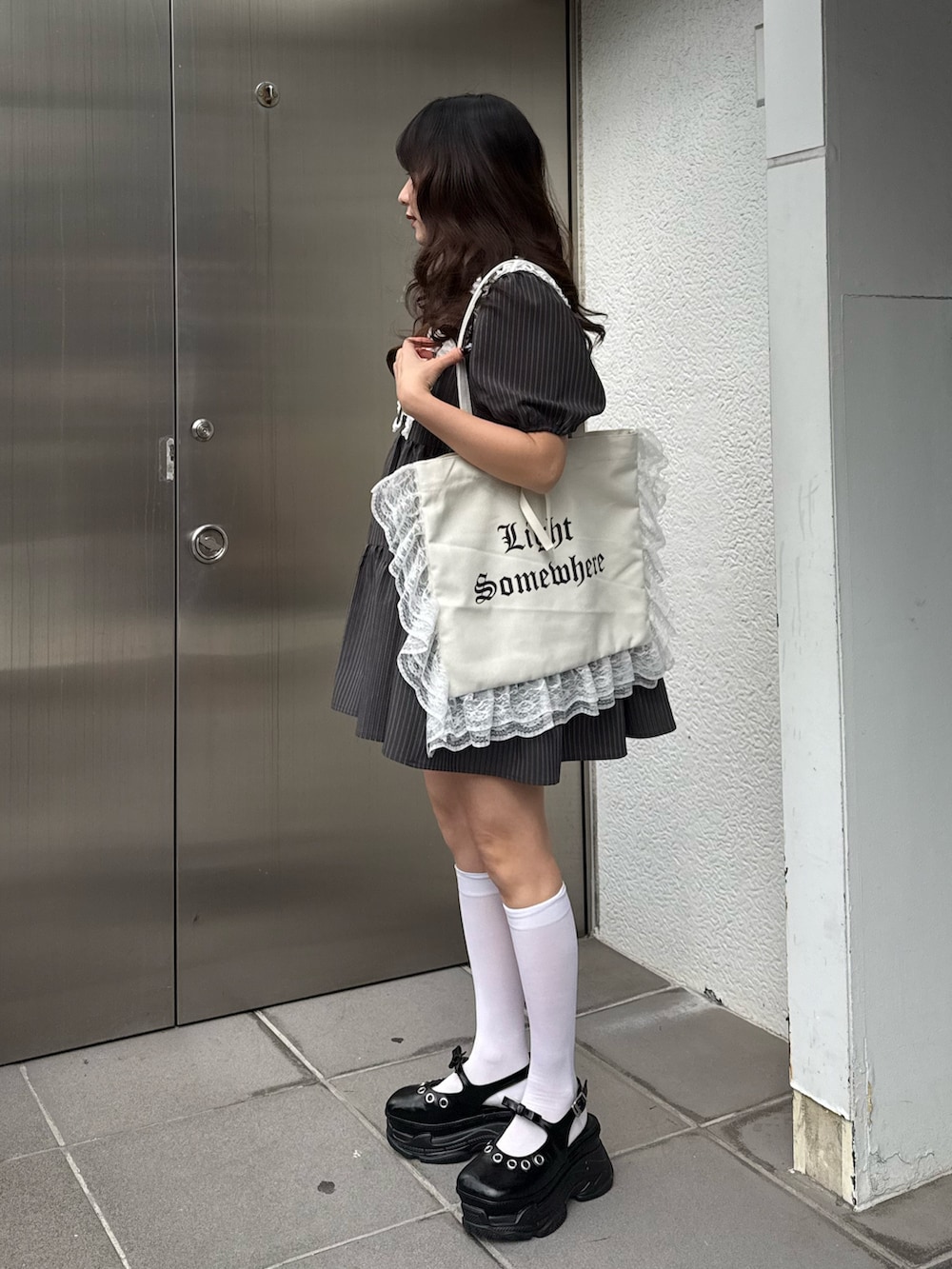 グレー系のワンピース、ホワイト系のトートバッグを着用したレディースの冬コーディネートの3枚目の写真