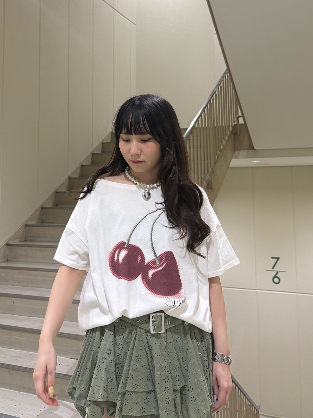 ホワイト系のTシャツ/カットソー、ブラック系のブーツ、グリーン系のスカートを着用したレディースの春コーディネートの6枚目の写真
