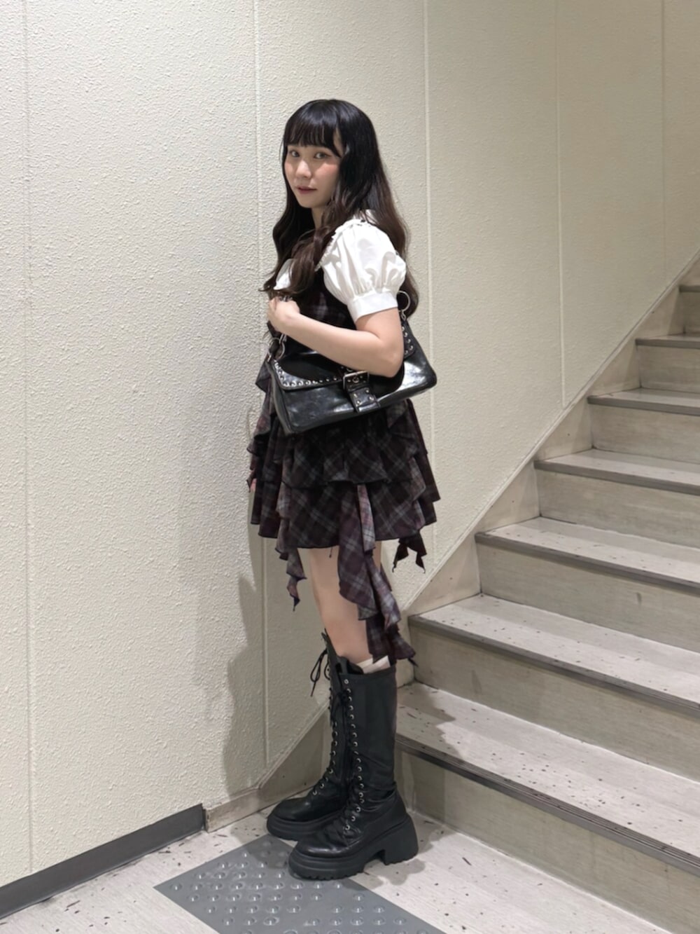 ホワイト系のシャツ/ブラウス、ブラック系のハンドバッグ、ブラック系のブーツを着用したレディースの夏コーディネートの2枚目の写真