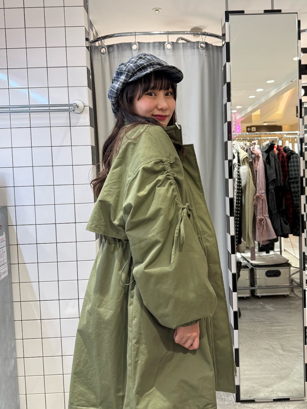 グリーン系のモッズコート、グレー系のニット/セーター、ブルー系のスカートを着用したレディースの冬コーディネートの8枚目の写真