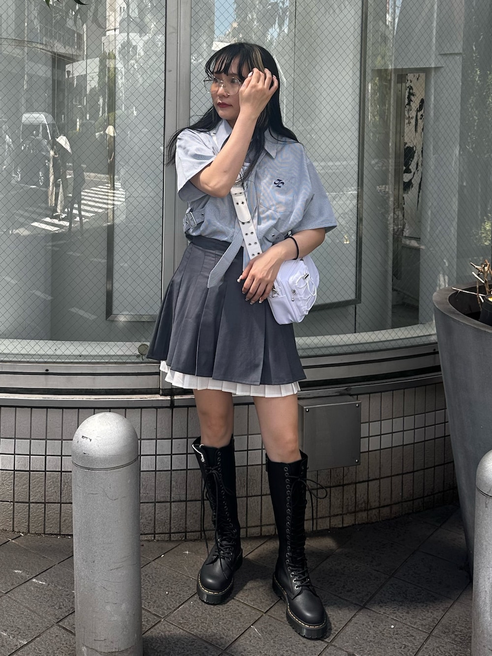 グレー系のスカート、ホワイト系のショルダーバッグ、ブルー系のシャツ/ブラウスを着用したレディースの夏コーディネートの2枚目の写真