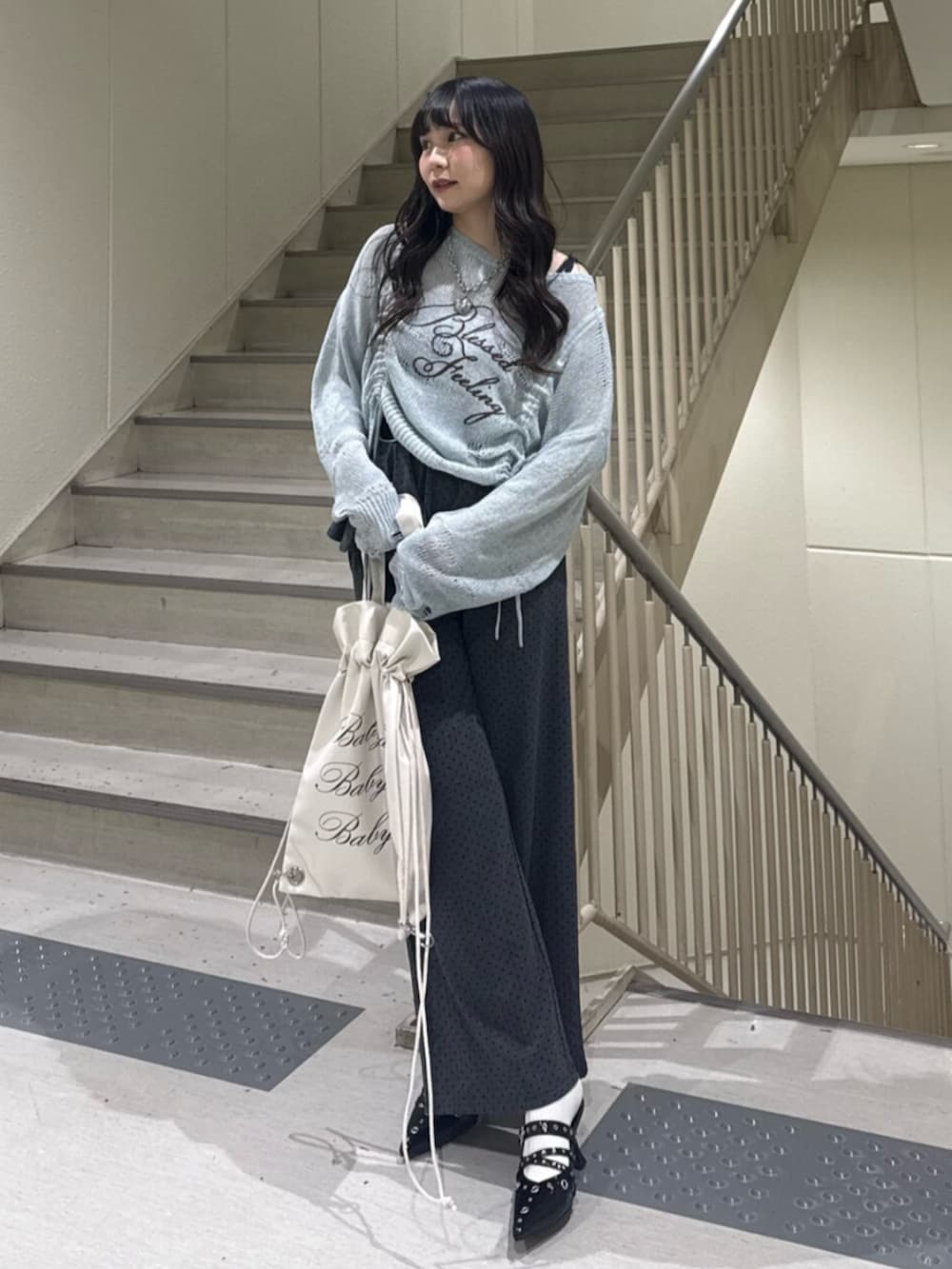 ブルー系のニット/セーター、グレー系のスウェットパンツ、ブラック系のパンプスを着用したレディースの春コーディネートの2枚目の写真