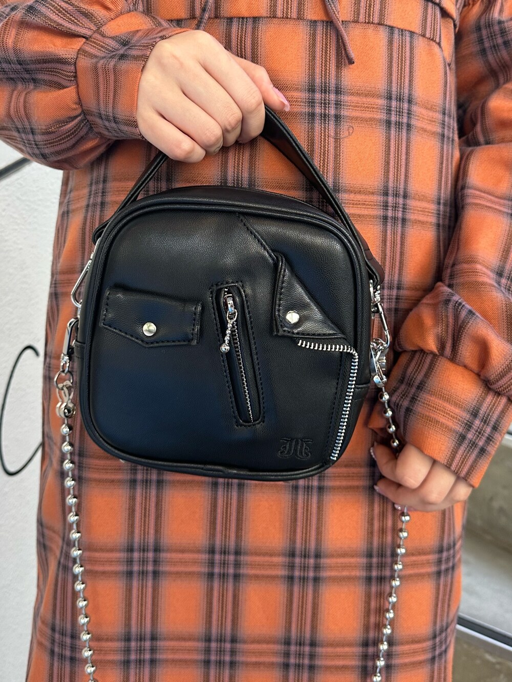 オレンジ系のワンピース、ホワイト系のハンドバッグ、ホワイト系のTシャツ/カットソーを着用したレディースの秋コーディネートの5枚目の写真