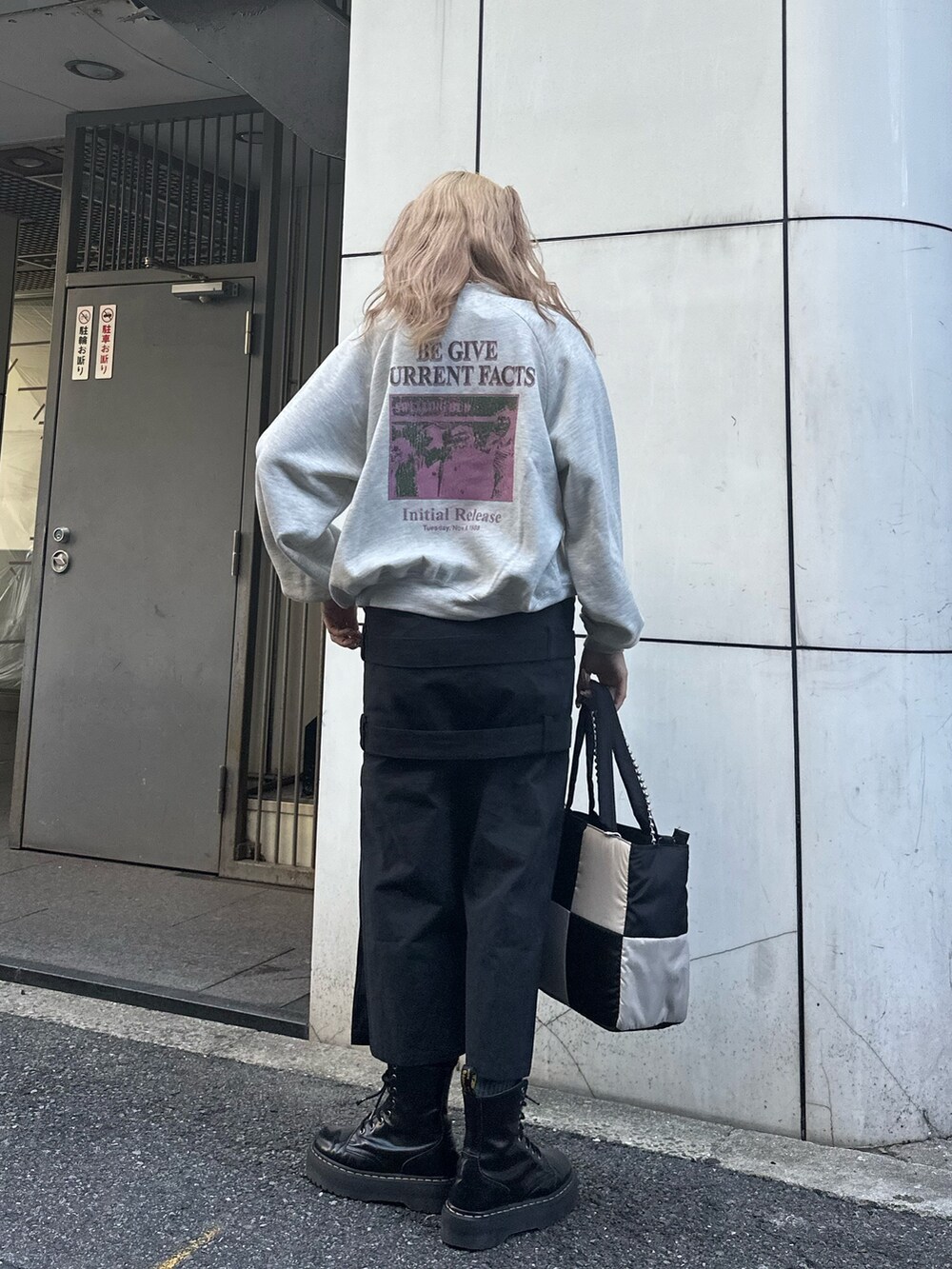 グレー系のスウェット、ブラック系のスカート、ブラック系のハンドバッグを着用したレディースの秋コーディネートの3枚目の写真