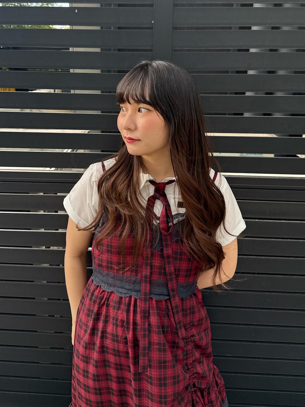 レッド系のワンピース、ブラック系のブーツ、ホワイト系のシャツ/ブラウスを着用したレディースの夏コーディネートの5枚目の写真