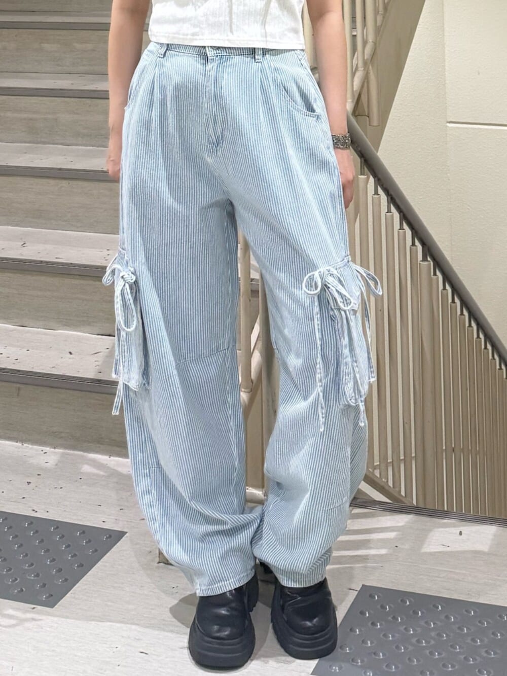 ブラック系のブーツ、ホワイト系のTシャツ/カットソー、ブルー系のデニムパンツを着用したレディースの春コーディネートの7枚目の写真