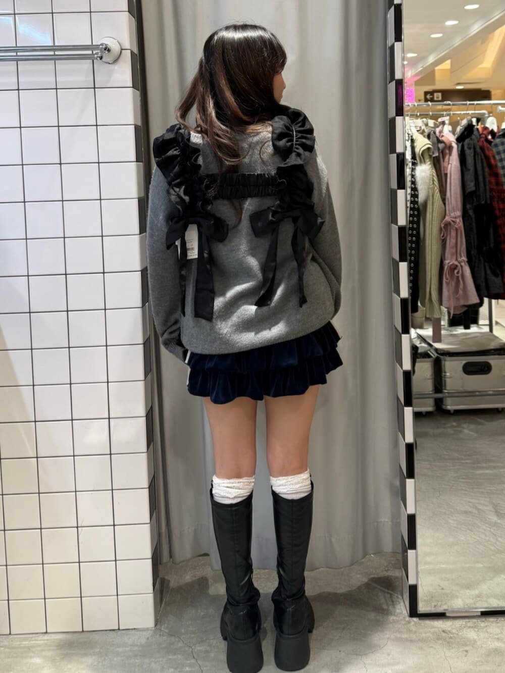 ブルー系のスカート、ブラック系のブーツ、グレー系のニット/セーターを着用したレディースの冬コーディネートの4枚目の写真