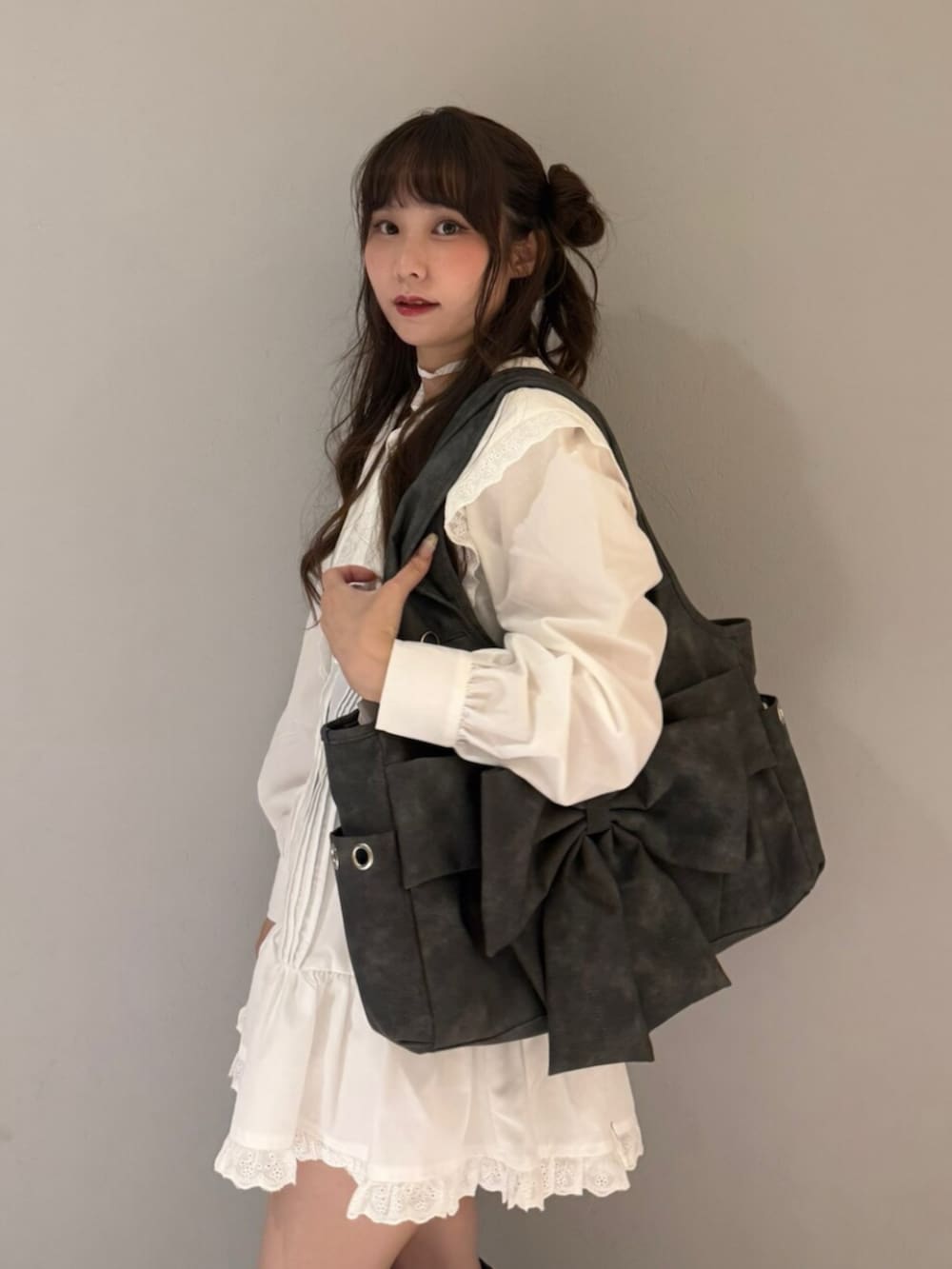 グレー系のトートバッグ、ブラック系のブーツ、ホワイト系のワンピースを着用したレディースの夏コーディネートの6枚目の写真