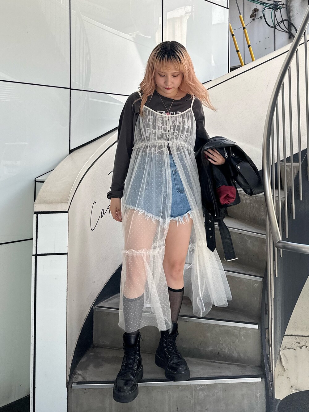 ブラック系のTシャツ/カットソー、ブラック系のライダースジャケット、ホワイト系のワンピースを着用したレディースの夏コーディネートの3枚目の写真