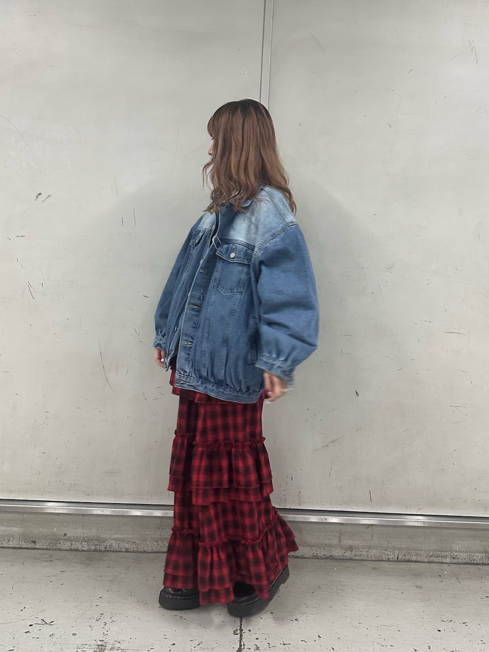 ブルー系のデニムジャケット、ホワイト系のニット/セーター、レッド系のスカートを着用したレディースの春コーディネートの2枚目の写真