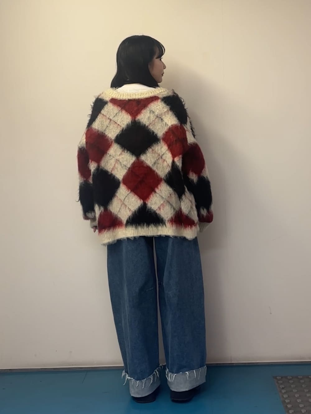 ホワイト系のカーディガン/ボレロ、ホワイト系のTシャツ/カットソー、ブルー系のデニムパンツを着用したレディースの秋コーディネートの3枚目の写真