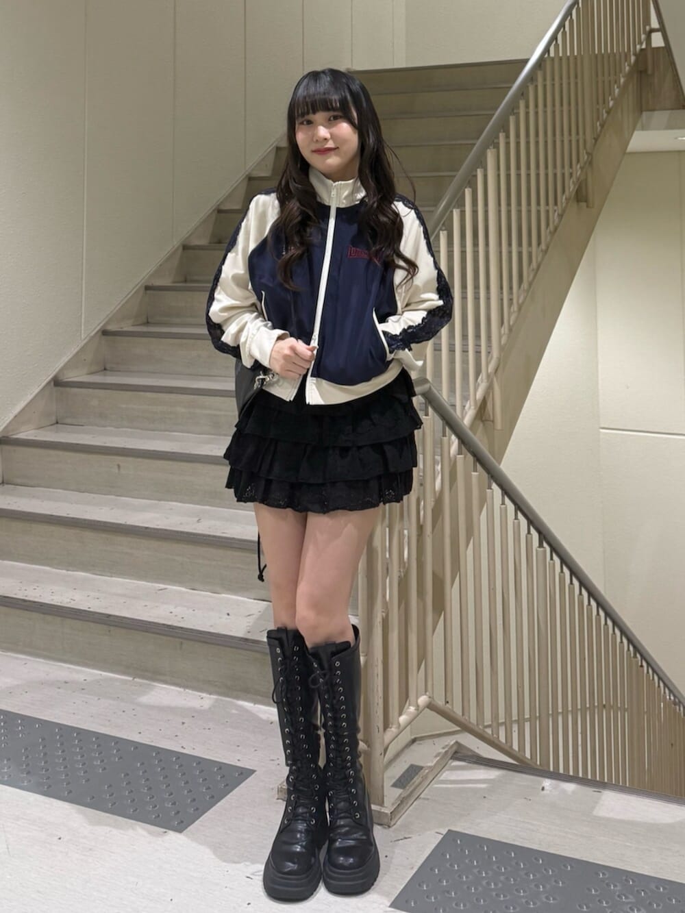 ブラック系のブーツ、ブルー系のジャージ、ブラック系のスカートを着用したレディースの春コーディネートの2枚目の写真