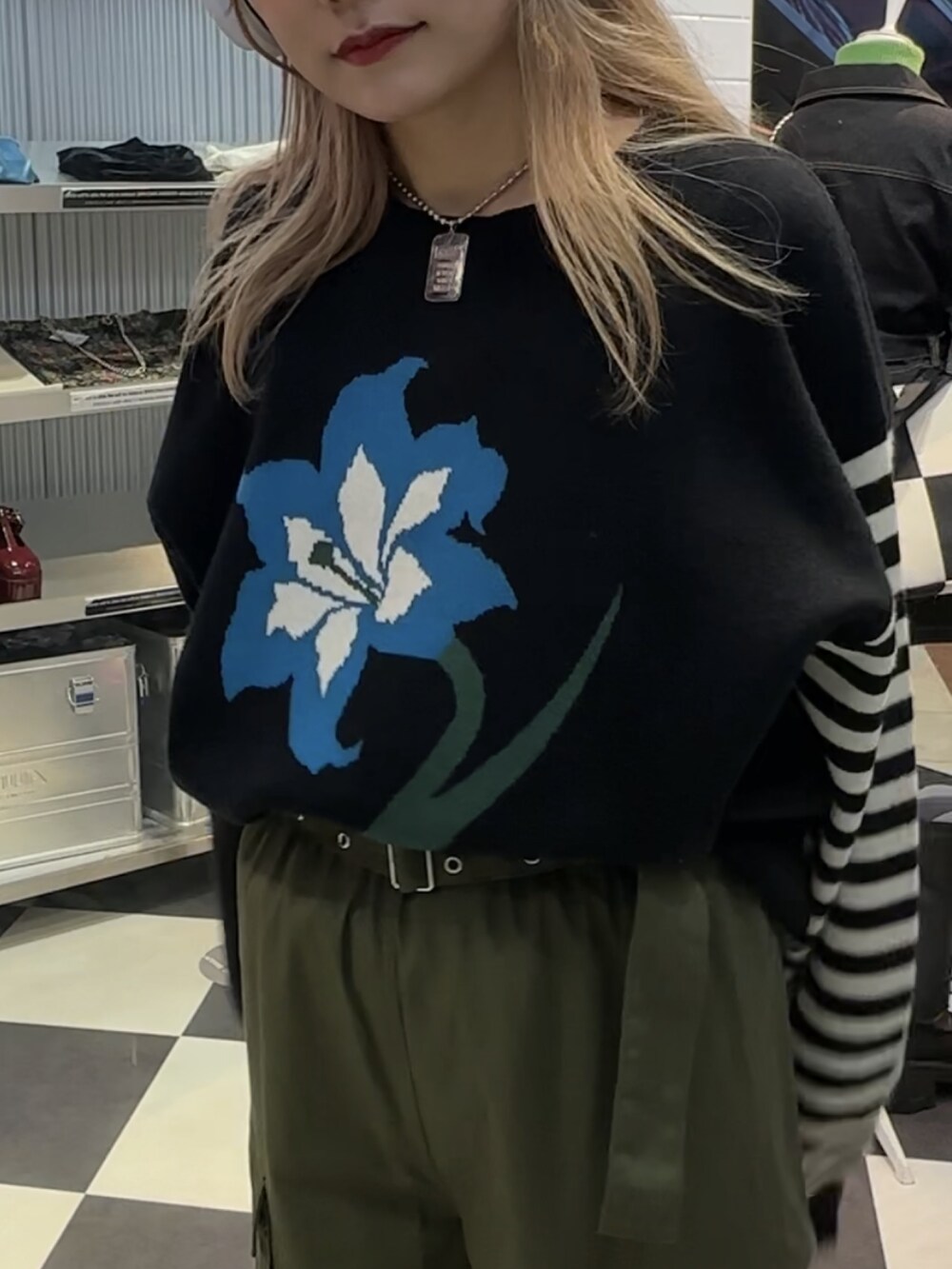 グリーン系のカーゴパンツ、ブラック系のニット/セーター、シルバー系のネックレスを着用したレディースの秋コーディネートの3枚目の写真