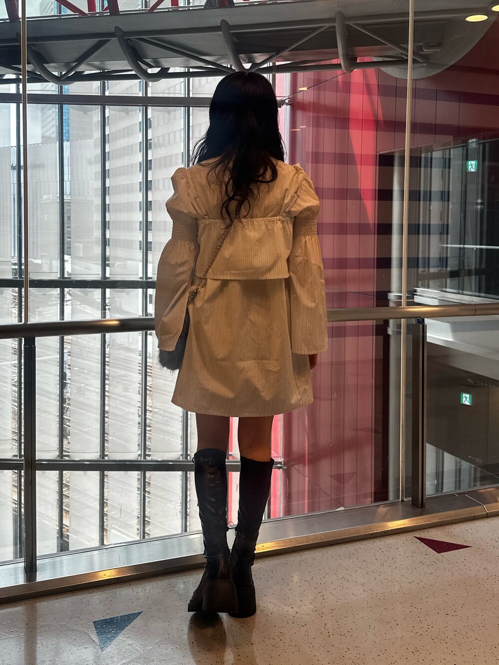 ホワイト系のシャツワンピース、ブルー系のハンドバッグ、ブラック系のブーツを着用したレディースの夏コーディネートの4枚目の写真