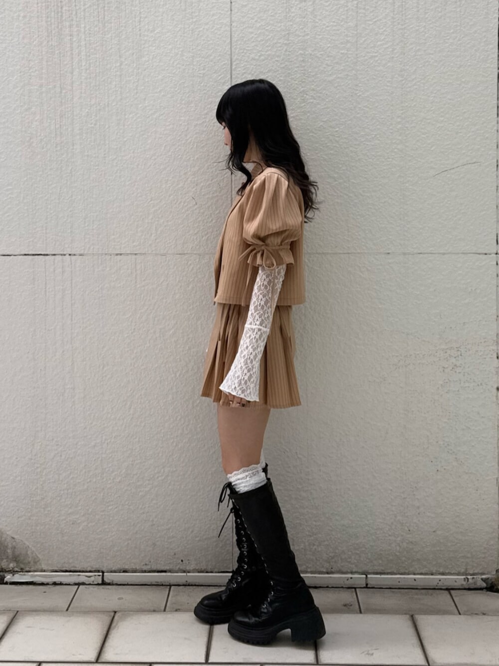 ブラック系のブーツ、ホワイト系のTシャツ/カットソー、ベージュ系のテーラードジャケットを着用したレディースの冬コーディネートの3枚目の写真