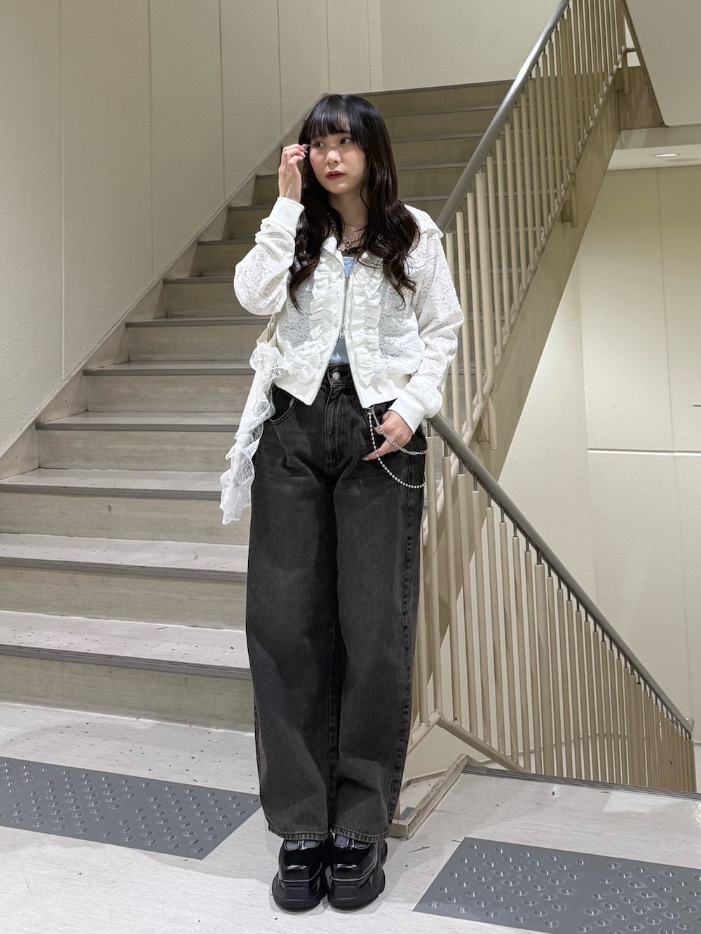 ホワイト系のパーカー、ブラック系のデニムパンツ、ホワイト系のトートバッグを着用したレディースの春コーディネートの2枚目の写真