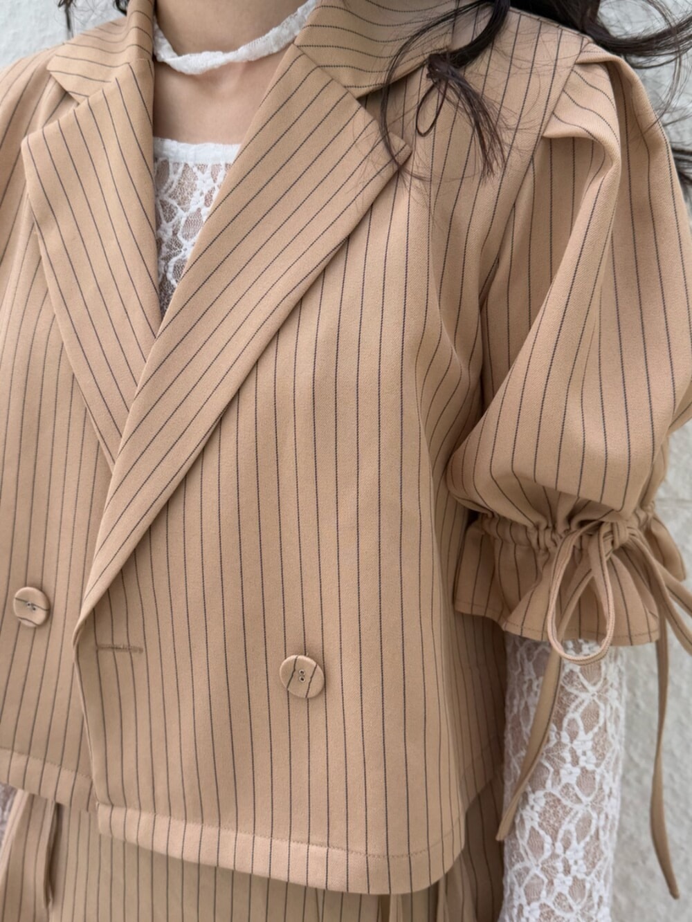 ブラック系のブーツ、ホワイト系のTシャツ/カットソー、ベージュ系のテーラードジャケットを着用したレディースの冬コーディネートの7枚目の写真