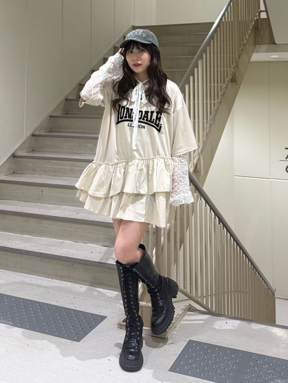 ブラック系のブーツ、ホワイト系のワンピース、ホワイト系のTシャツ/カットソーを着用したレディースの春コーディネートの2枚目の写真