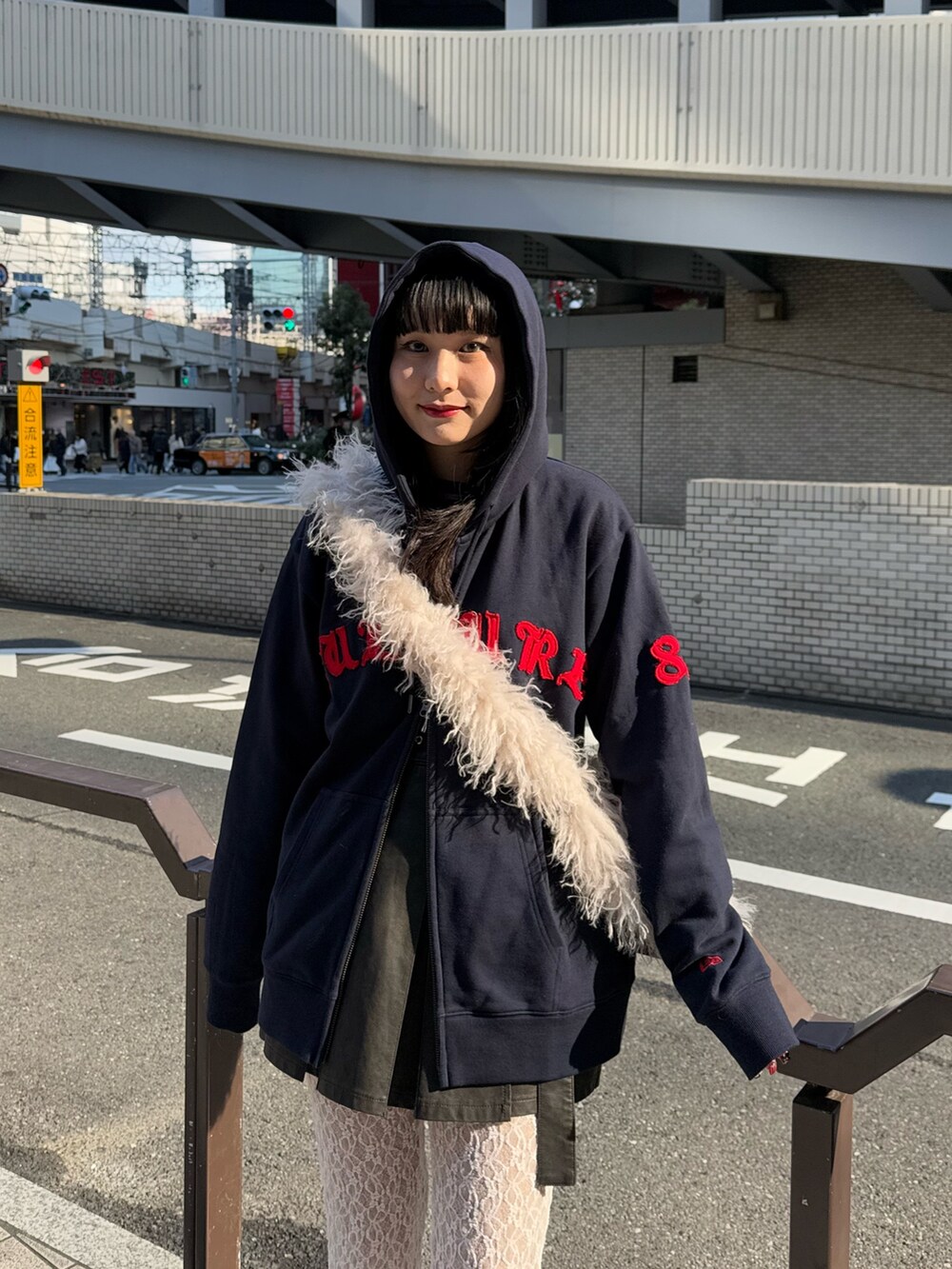 ブルー系のパーカー、ホワイト系のショルダーバッグ、ブラック系のスカートを着用したレディースの冬コーディネートの5枚目の写真