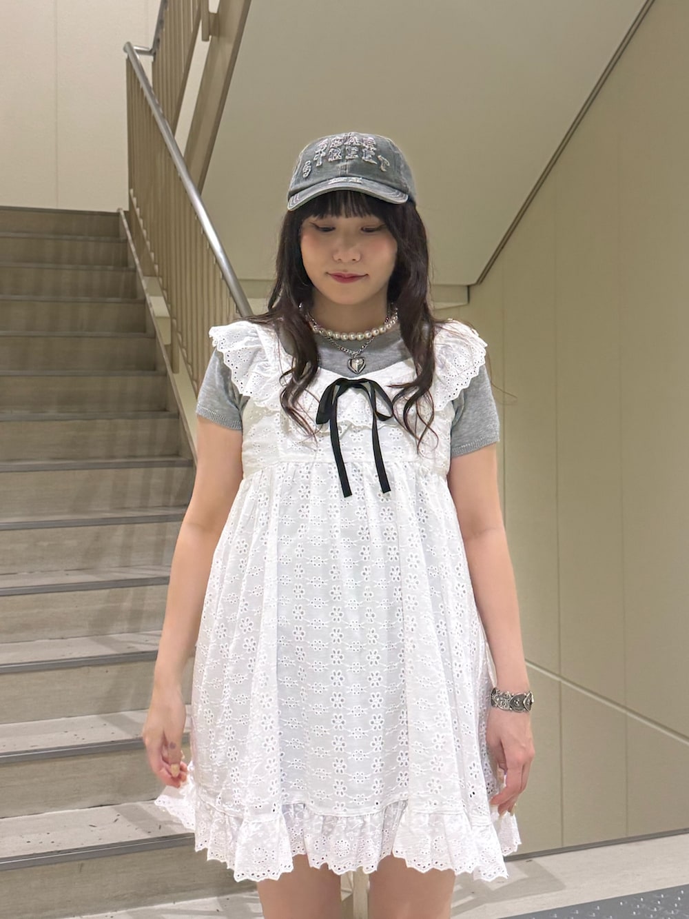ホワイト系のワンピース、グレー系のTシャツ/カットソー、ブラック系のブーツを着用したレディースの春コーディネートの7枚目の写真