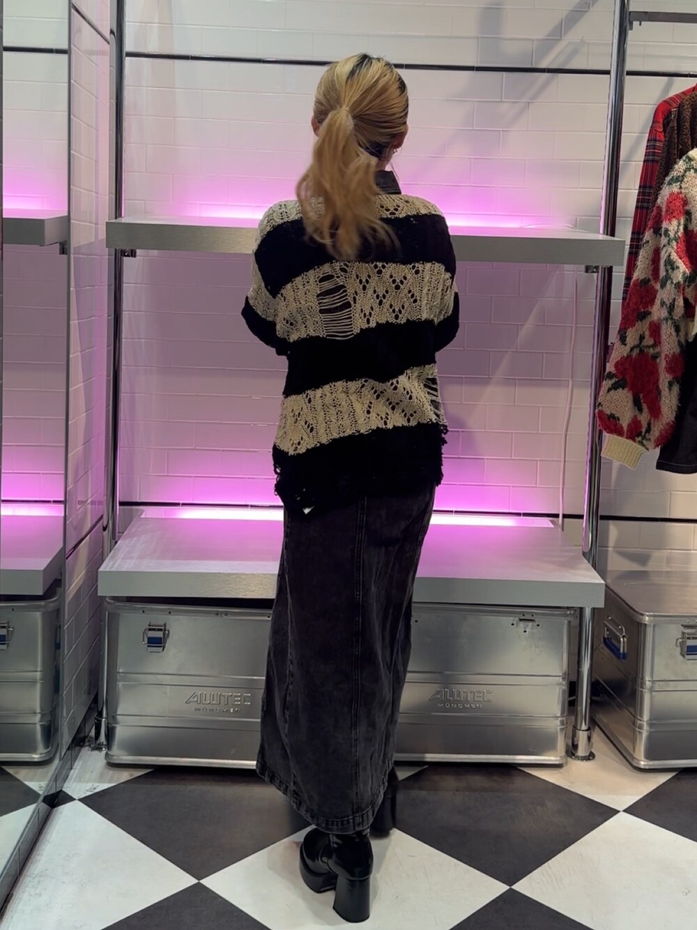 ブラック系のニット/セーター、ブラック系のワンピース、ブラック系のブーツを着用したレディースの冬コーディネートの3枚目の写真