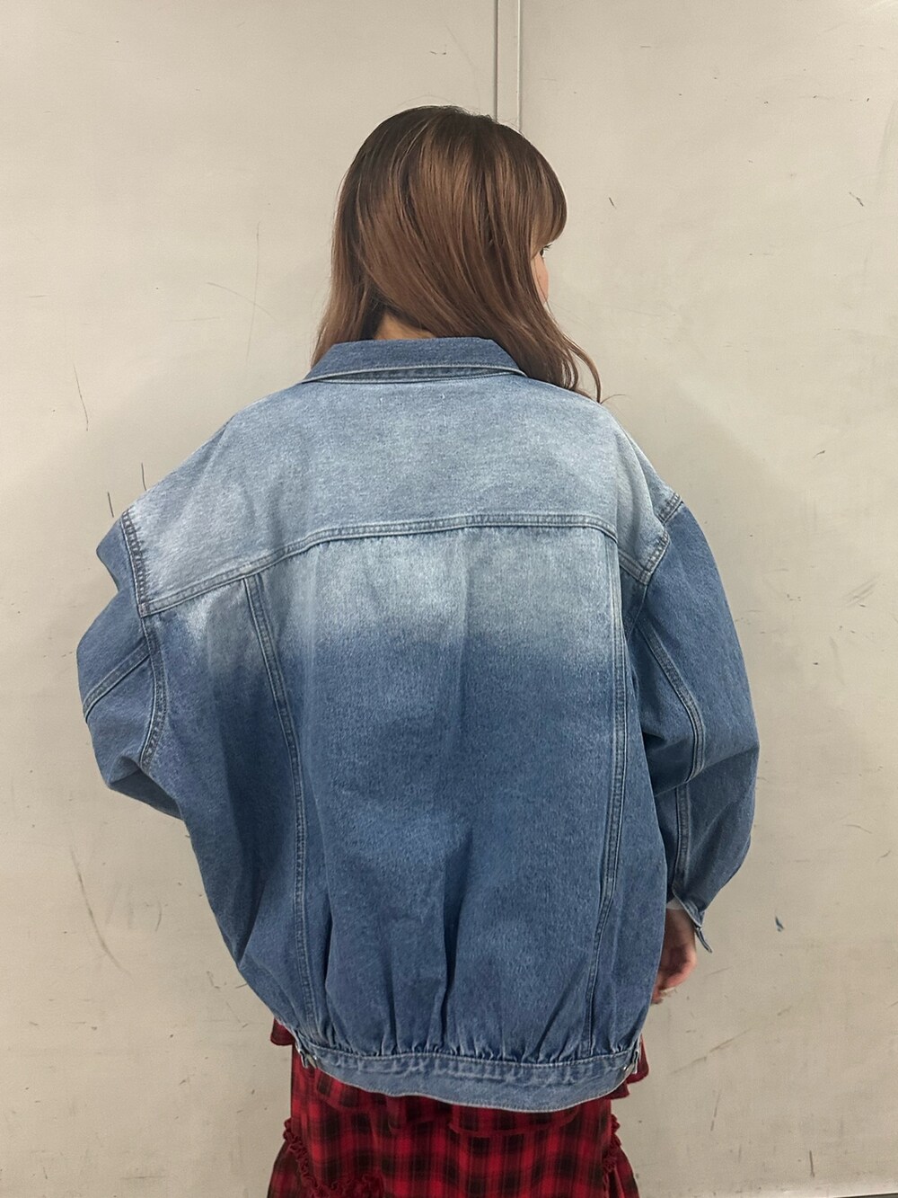 ブルー系のデニムジャケット、ホワイト系のニット/セーター、レッド系のスカートを着用したレディースの春コーディネートの4枚目の写真