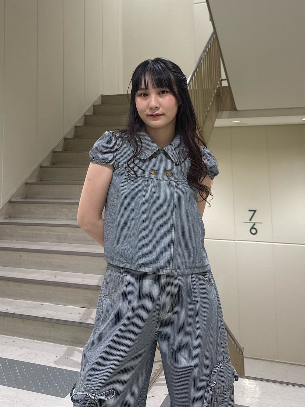ブラック系のデニムパンツ、ブラック系のブーツ、ブラック系のその他トップスを着用したレディースの春コーディネートの9枚目の写真