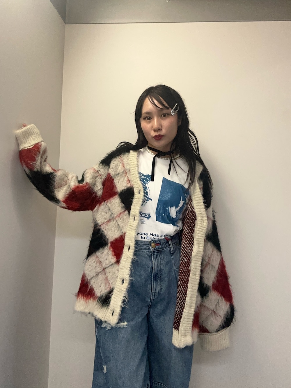 ホワイト系のカーディガン/ボレロ、ホワイト系のTシャツ/カットソー、ブルー系のデニムパンツを着用したレディースの秋コーディネートの6枚目の写真