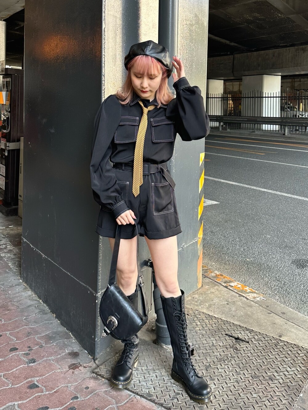 ブラック系のつなぎ/オールインワン、ブラック系のショルダーバッグ、ブラック系のブーツを着用したレディースの春コーディネートの2枚目の写真