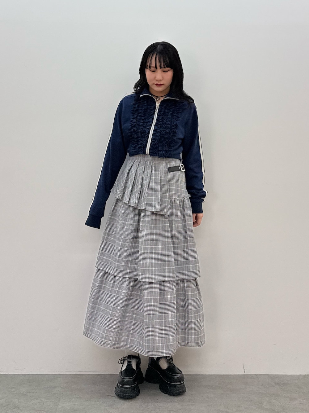 ブルー系のジャージ、グレー系のスカート、ブラック系のスニーカーを着用したレディースの春コーディネートの4枚目の写真