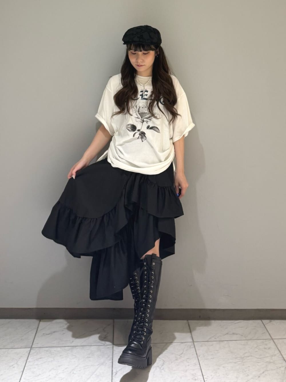 ブラック系のブーツ、ホワイト系のTシャツ/カットソー、ブラック系のスカートを着用したレディースの夏コーディネートの4枚目の写真