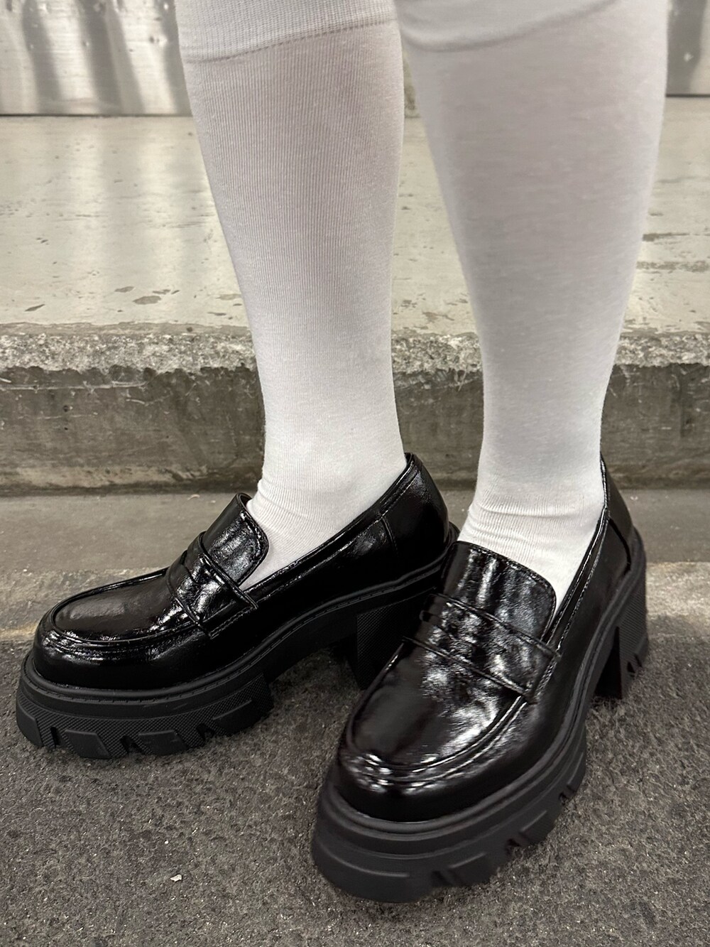 ブラック系のワンピース、ブラック系のローファー、レッド系のスウェットを着用したレディースの冬コーディネートの5枚目の写真