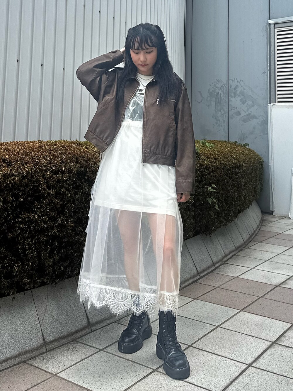 ブラウン系のブルゾン、ホワイト系のワンピース、シルバー系のネックレスを着用したレディースの夏コーディネートの4枚目の写真