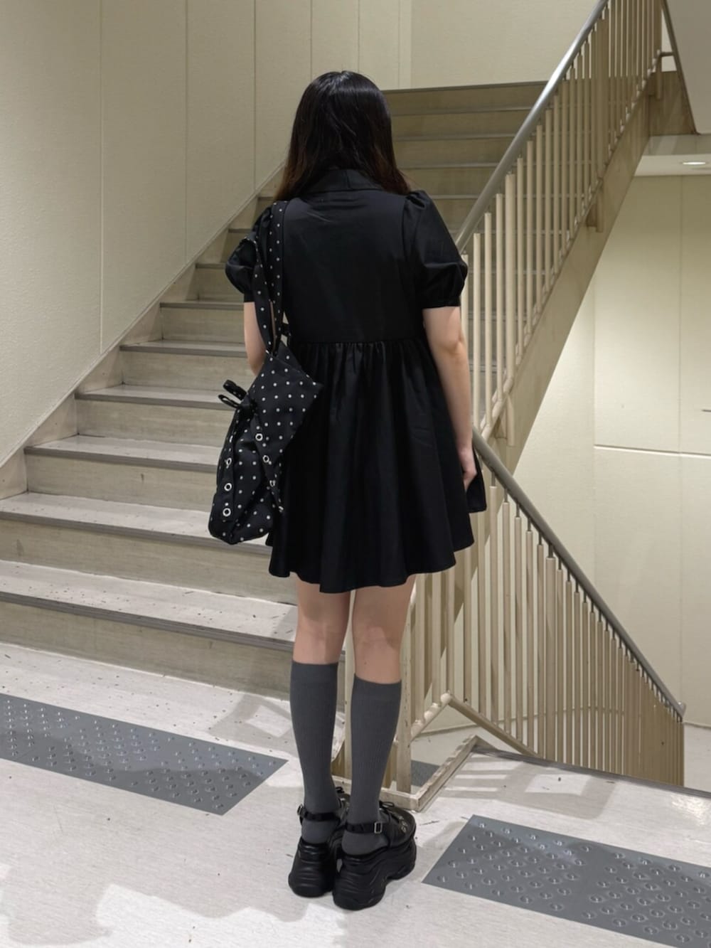 ブラック系のパンプス、ブラック系のワンピース、その他のトートバッグを着用したレディースの夏コーディネートの3枚目の写真