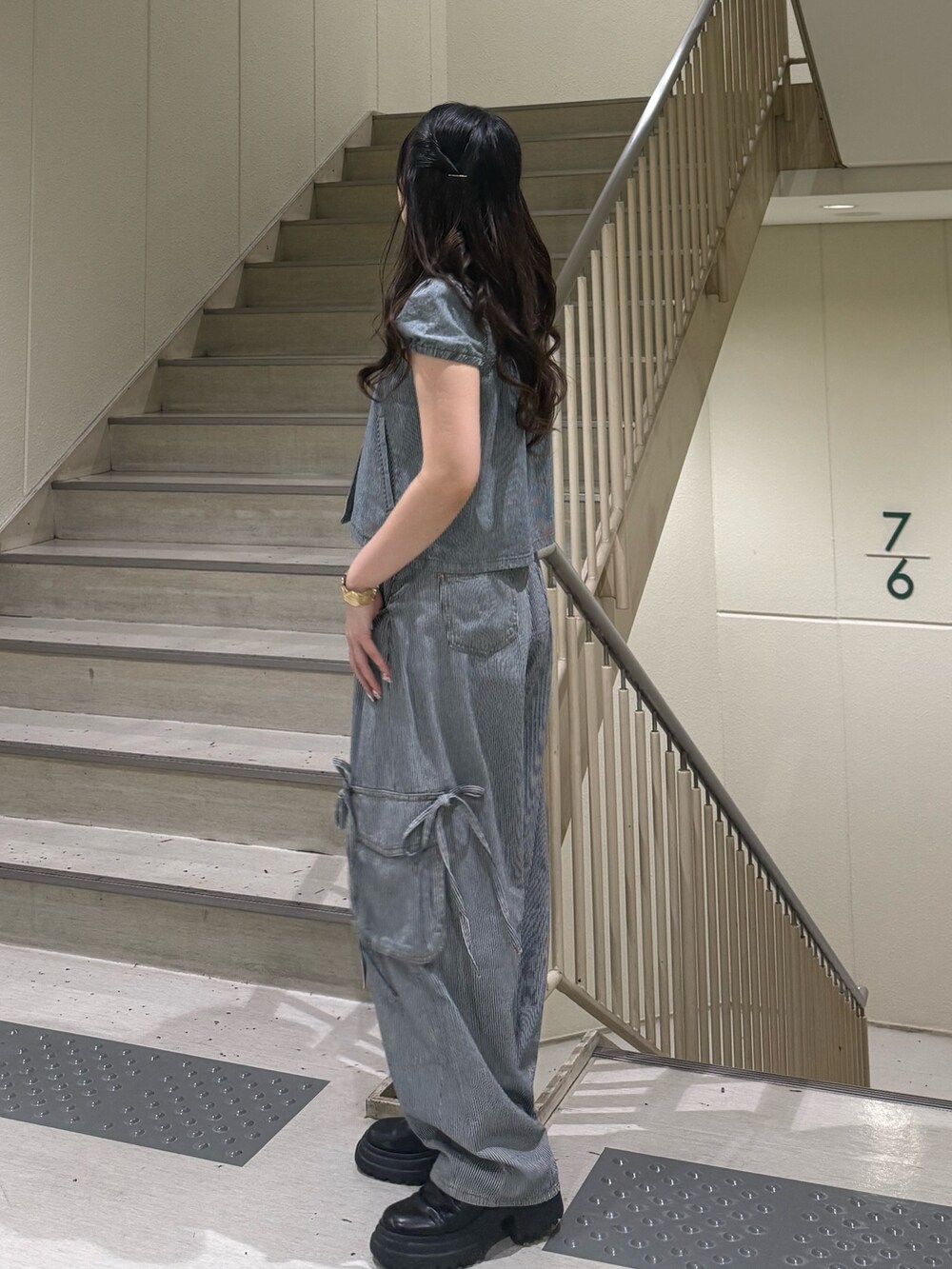 ブラック系のデニムパンツ、ブラック系のブーツ、ブラック系のその他トップスを着用したレディースの春コーディネートの4枚目の写真